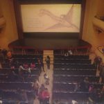MovieMovil, la empresa de cine al aire libre, cierra con éxito una proyección en el Teatro Principal de Banyeres de Mariola Interior del Teatro Principal de Banyeres de Mariola al finalizar una película, con el público de pie y saliendo de sus asientos mientras en la pantalla se proyectan los créditos finales, mostrando nombres como Karen Foster, Doug Davison, Roy Lee y Michael Connolly. MovieMovil, la empresa de cine al aire libre