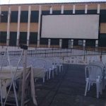 MovieMovil, la empresa de cine al aire libre, celebra las fiestas de la Malena con una proyección especial en Banyeres de Mariola Proyección de cine al aire libre en el patio de un colegio en Banyeres de Mariola durante las fiestas de la Malena, con una pantalla grande, sillas blancas para el público y un ambiente festivo. MovieMovil, la empresa de cine al aire libre