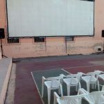 MovieMovil, la empresa de cine al aire libre, presenta una experiencia única en el antiguo campo de fútbol de Monóvar Pantalla de cine al aire libre montada en el antiguo campo de fútbol de Monóvar, con sillas de plástico blanco dispuestas frente a ella. MovieMovil, la empresa de cine al aire libre.