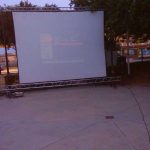 MovieMovil la empresa del cine al aire libre transforma espacios abiertos en escenarios mágicos para disfrutar del cine bajo las estrellas. Proyección de cine al aire libre, organizada por MovieMovil la empresa del cine al aire libre, con pantalla de 6,5 metros y un ambiente comunitario en un espacio abierto.