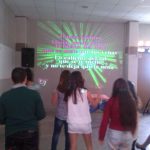 MovieMovil, la empresa de cine al aire libre, añade diversión y música a las fiestas infantiles con proyecciones de karaoke Proyección en la pared de karaoke durante una fiesta infantil, mostrando la letra de la canción "Danza Kuduro", con niños y niñas participando activamente frente a la proyección. MovieMovil, la empresa de cine al aire libre