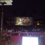 MovieMovil la empresa del cine al aire libre transforma espacios únicos en escenarios mágicos para disfrutar del cine bajo las estrellas. Proyección de cine al aire libre, organizada por MovieMovil la empresa del cine al aire libre, con pantalla gigante y un ambiente comunitario nocturno.